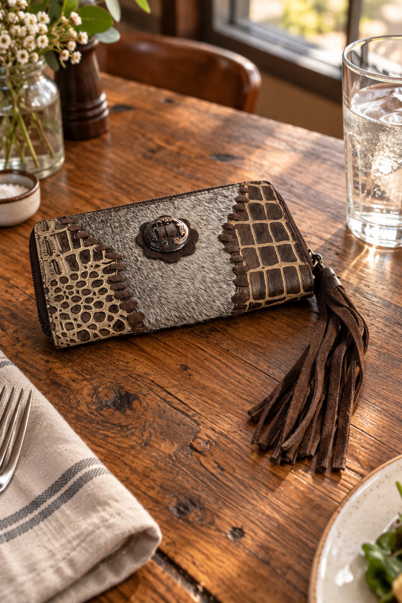 Crocodile print with whip stitched. Fringe tassel on zipper. Silver-toned medallion and leatherwork detail on front.
Multiple card slots on interior.