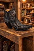 A black western-style boot with silver-toned embroidered swirls and studded details.
